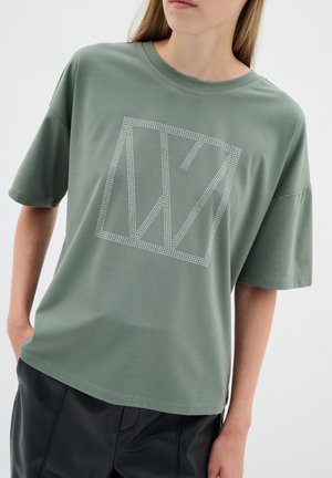 Ljusgrön kortärmad t-shirt med rund halsringning, prydd med ett diamantmönster i vita rhinestones. Slät, mjuk tyg.