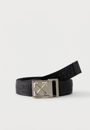 Black fabric belt with a silver buckle featuring a raised four-arrow design, partially coiled on a white surface.