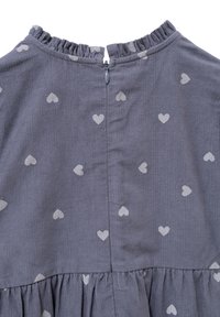 Vestido de tela gris con pequeños patrones de corazones blancos, un escote con volantes y cierre de cremallera en la parte posterior; detalle de falda plisada en la parte inferior.
