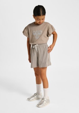 Grijs katoenen T-shirt met korte ruches aan de mouwen en een zilveren afbeelding, gecombineerd met grijze shorts met een elastische tailleband en een trekkoord. Zilveren sneakers.