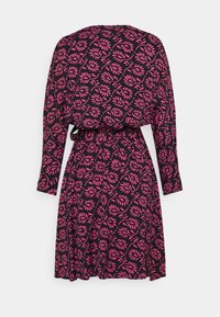 Zwarte jurk met roze bladpatroon, lange mouwen en een ceintuur in de taille. Vloeiende stof valt net onder de knie.