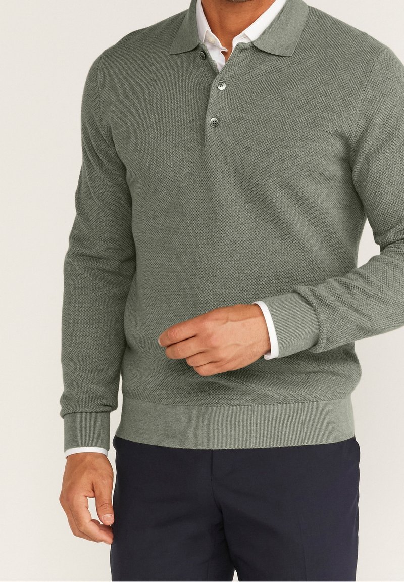 Grüner Strickpullover mit Kragen, drei Knöpfen sowie gerippten Bündchen an Ärmeln und Saum, mit strukturierter Stoffmusterung.