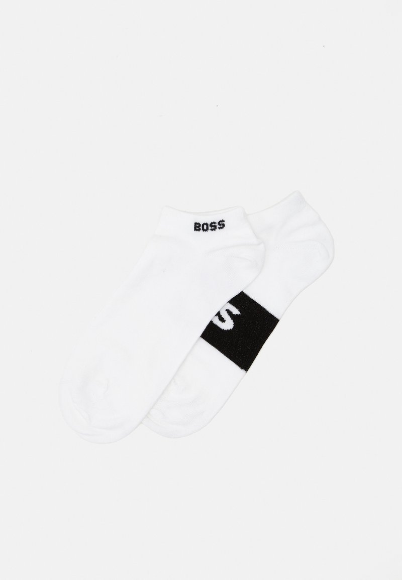 White ankle socks featuring a black logo on the cuff and a black band across the mid-foot; cotton material with a smooth texture.