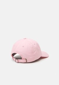 Pink baseball cap made of cotton. Features a curved brim, adjustable back strap with metal hardware, and a stitched top button.