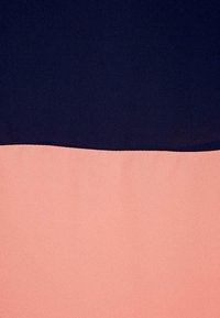Tkanina se dvěma barvami - temně modrá horní polovina a jemně broskvová dolní polovina. Hladká textura, která vytváří čisté oddělení ve středu.