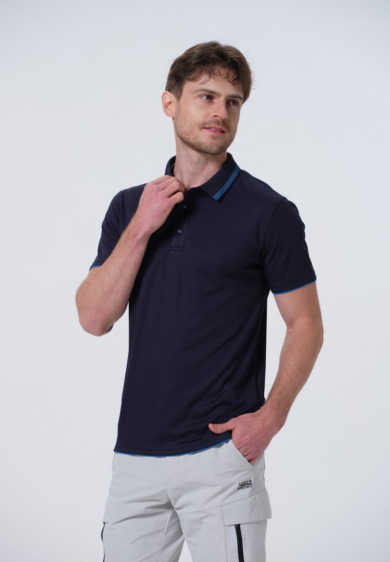 Polo shirt blu navy con colletto e una striscia azzurra a contrasto. Maniche corte e vestibilità slim con chiusura a due bottoni.
