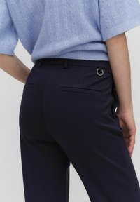 Marina byxor i strukturerad väv, med en skräddarsydd passform, sidfickor och bakfickor, samt en silverring som detalj vid midjan.