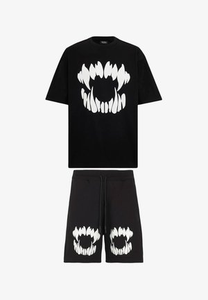Set di maglietta in cotone nero e pantaloni corti con una grande grafica di un dente bianco sulla parte anteriore e fauci aggiuntive sui pantaloni corti. Vita regolabile con cordino.