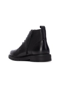 Botas de tobillo de cuero en negro con un acabado texturizado, que presentan una cremallera lateral, un diseño con cordones y una suela baja de goma texturizada.