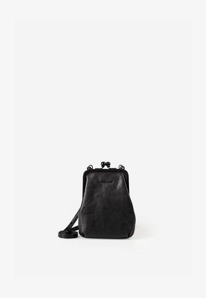 Kleine schwarze Leder-Crossbody-Tasche mit Verschlussrahmen und verstellbarem Riemen, aufrecht stehend vor weißem Hintergrund.