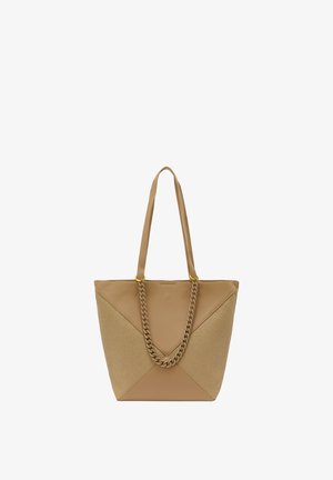 Beige vászontáska két hosszú fogantyúval. Sima textúrával és fonott lánc díszítéssel rendelkezik. A háromszögletű panel dizájn vizuális érdekességet ad hozzá.