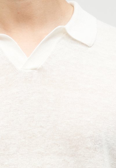 Μπεζ ανοιχτό μπεζ πουλόβερ με V λαιμόκοψη, ριμπ ύφανση στη λαιμόκοψη, πλεκτή υφή και ελαφρώς διαφανή εμφάνιση. Το ύφασμα είναι μαλακό με ένα casual σχέδιο.