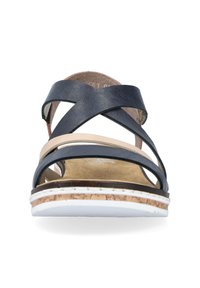 Sandale bleu marine avec des brides croisées, sangle intermédiaire beige et un talon avec texture semblable au liège. Semelle blanche avec des détails de surpiqûres visibles.