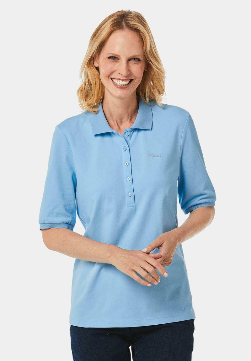 Hellblaues Polohemd mit kurzen Ärmeln, mit einem kragenartigen Ausschnitt, vier Knöpfen und einem dezenten Logo auf der Brust. Weicher Stoff.