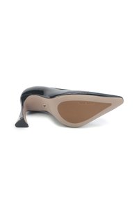 Chaussure à talon aiguille en cuir verni noir, pointue, posée sur le côté, montrant une semelle beige avec la marque "Nine West".