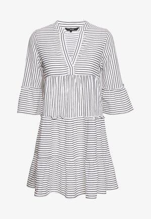 Pasiasta sukienka w białym i czarnym kolorze, z dekoltem w serek, warstwowym krój, rękawami dzwonami oraz teksturowanym materiałem o różnej szerokości pasków.