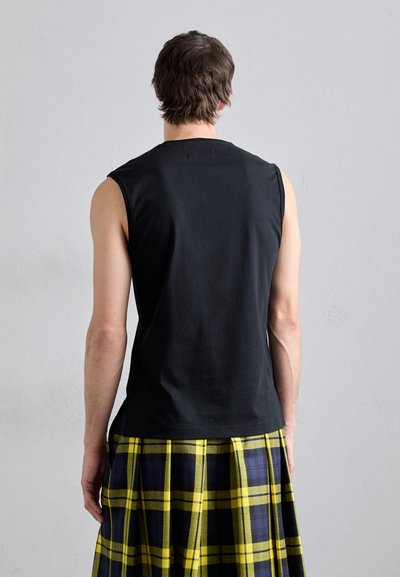 Schwarzes ärmelloses Oberteil kombiniert mit einem gelb-blauen Kilt in Karomuster. Der Stoff wirkt weich mit einer glatten Textur und minimalistischem Design.
