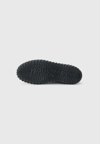 Semelle de chaussure en caoutchouc noir présentant un motif de semelle texturé et le texte en relief "paul green". Les bords arrondis améliorent la traction et la stabilité.
