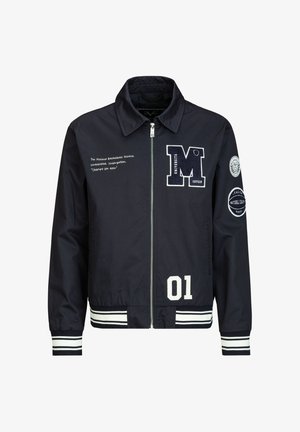 Marineblaue Varsity-Jacke mit Reißverschluss, weißen gestreiften Bündchen und Saum, Patches mit "M Universita", "01" und Text auf Brust und Ärmeln.