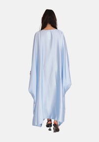 Lichtblauwe satijnen kaftan met vloeiende stijl, brede mouwen en een ronde halslijn. Kenmerkt zich door een subtiele zoom en valt elegant.