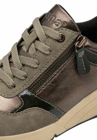 Gray suede sneaker with metallic bronze accents, textured laces, side zipper detail, and a cream rubber sole. Features contrast stitching.