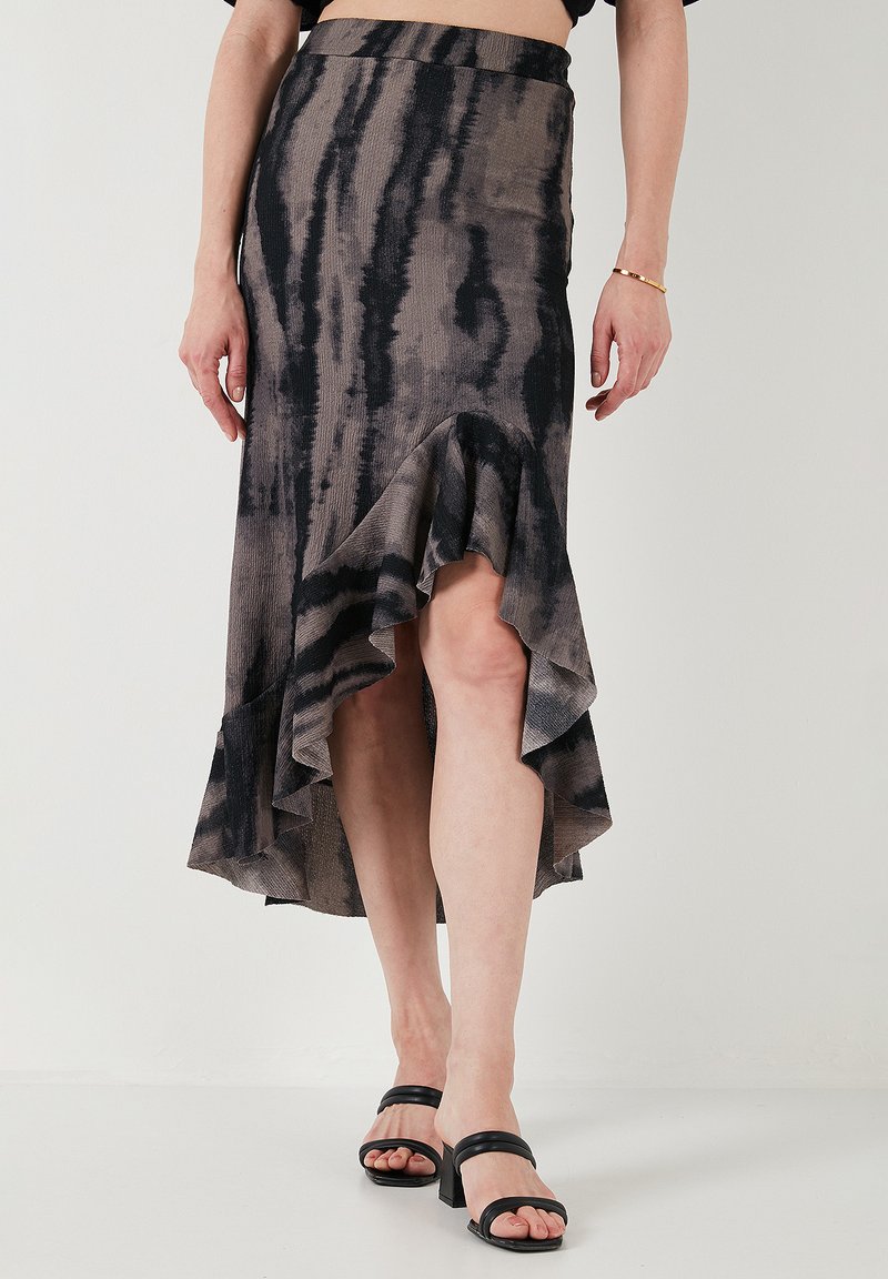 Falda midi de estampado negro y topo con dobladillo acampanado, hecha de una tela texturizada, que presenta un diseño asimétrico.