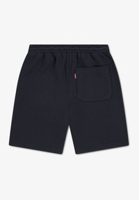 Shorts en coton bleu marine foncé avec une taille élastique, comprenant une poche arrière unique et une petite étiquette logo rouge. Texture lisse.