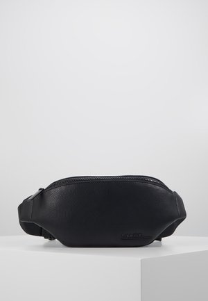 Czarna skórzana nerka o teksturowanej powierzchni, z górnym zamkiem błyskawicznym i płaskim logo. Regulowany pasek do noszenia na różne sposoby.