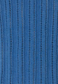 Niebieska dzianina z pionowymi paskami na przemian w pełnych i ażurowych sekcjach, prezentująca teksturowany, warstwowy wygląd.