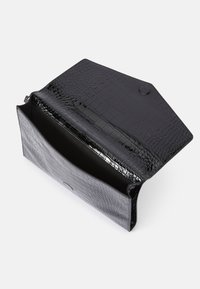 Bolso de mano negro de crococodrilo con acabado brillante, que presenta un cierre de solapa y un interior amplio y forrado.