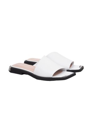 Sandales blanches à glisser avec une tige synthétique lisse, un design à bout ouvert et une semelle noire plate. Présente une forme légèrement carrée.