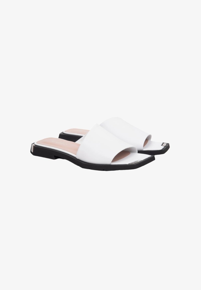 Weiße Rutschsandalen mit einem glatten synthetischen Obermaterial, offenes Zehendesign und einer flachen schwarzen Sohle. Mit einer leicht quadratischen Form.