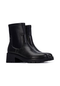 Stivali alla caviglia in pelle nera con punta rotonda, pannelli elastici sui lati e un tacco spesso e testurizzato. Design minimalista e finitura liscia.