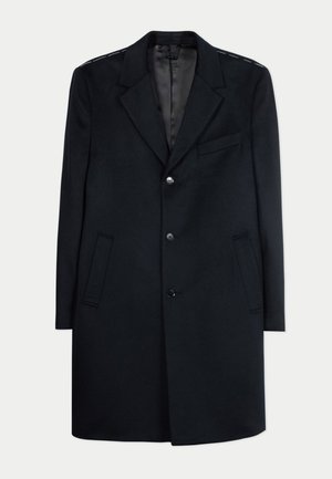 Schwarzer Wollmantel mittlerer Länge mit Reverskragen, drei Knöpfen, zwei Seitentaschen und einer Brusttasche, dargestellt vor weißem Hintergrund.