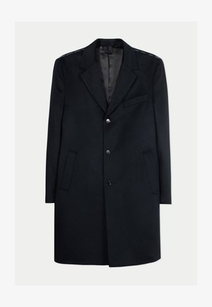 Manteau mi-long en laine noire avec revers crantés, trois boutons, deux poches latérales et une poche poitrine, présenté sur fond blanc.