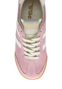 Zapatilla de ante rosa con rayas blancas, cordones crema y un logo dorado de "Gola" en la lengüeta. Suela de goma con sutiles detalles de textura.