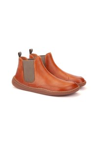 Botas de tobillo de cuero marrón con paneles laterales elásticos, diseño de punta redonda y suela de goma. Presenta detalles de costura y tiradores para facilitar el calzado.