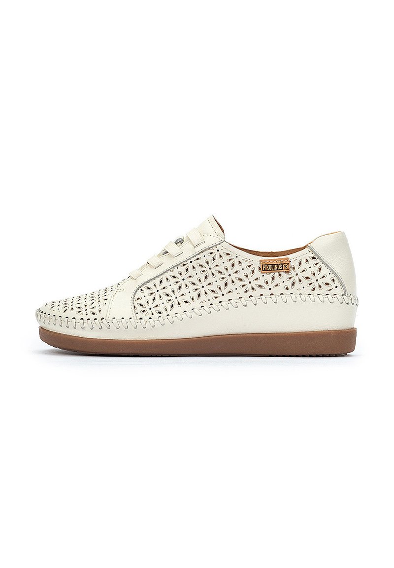 Zapatilla blanca de cuero con un patrón floral cortado, costuras beige a lo largo del borde y una suela de goma marrón. Diseño con cordones para un ajuste seguro.