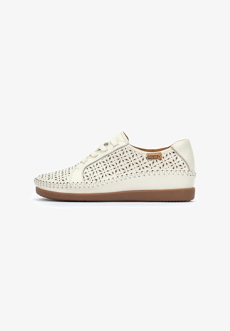 Zapatilla blanca de cuero con un patrón floral cortado, costuras beige a lo largo del borde y una suela de goma marrón. Diseño con cordones para un ajuste seguro.