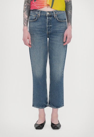 Lysblå denim jeans med en skræddersyet pasform, lige ben og rå kanter. Har klassisk fem-lomme design og minimale syninger som accents.