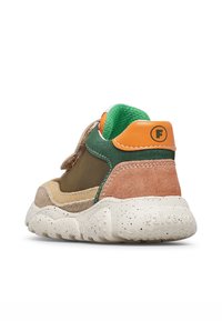 La sneaker presenta un design multicolore con accenti beige, verde e arancione, un materiale scamosciato testurizzato e una suola maculata.