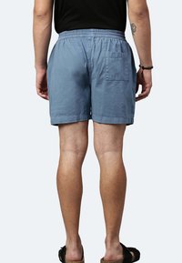 Shorts in misto cotone di colore azzurro chiaro, con vita elastica, una tasca posteriore singola e una vestibilità rilassata sopra il ginocchio.