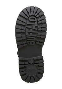 Suela de zapato de goma negra con patrones de relieve profundos, con la palabra "BUFFALO" en relieve y un logotipo circular en el talón.