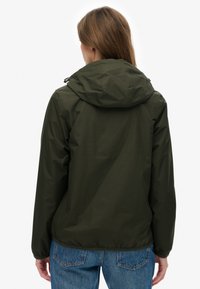 Zielona kurtka z kapturem wykonana z lekkiego, wodoodpornego materiału. Posiada elastyczne mankiety i ściągany dół zapewniające dopasowanie.