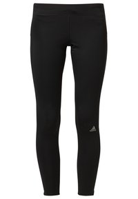Černé sportovní legíny s přiléhavým střihem, vyrobené z elastického materiálu. Na levém kotníku je malá stříbrná značka Adidas.