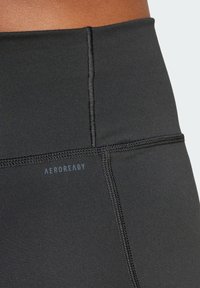 Černé vysoko pasové sportovní legíny s logem AEROREADY, vyrobené z hladké, elastické tkaniny a se švy plochého uzávěru pro pohodlí a odolnost.