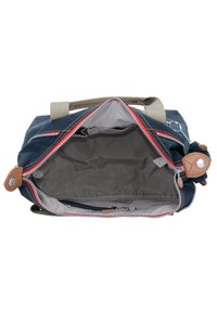 Segeltuchtasche in Marineblau mit einem hellgrauen Innenfutter. Verfügt über einen Reißverschluss oben, Akzente aus braunem Leder und einen zweifarbigen Trageriemen. Der Innenraum beinhaltet Taschen.