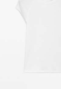 T-shirt en coton blanc avec un col rond et des manches raglan courtes, à la texture lisse et à l'ourlet droit. Design simple sans motifs.