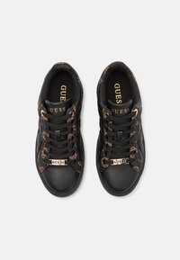 Baskets en cuir noir avec une marque en ton doré et une bordure en tissu à motif. Design à lacets avec une semelle texturée pour une meilleure adhérence.