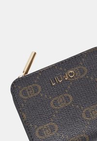 Portafoglio nero con texture, impreziosito da dettagli dorati, presenta un motivo ripetuto con il logo e una zip dorata, riportando il nome del marchio "LIU JO."